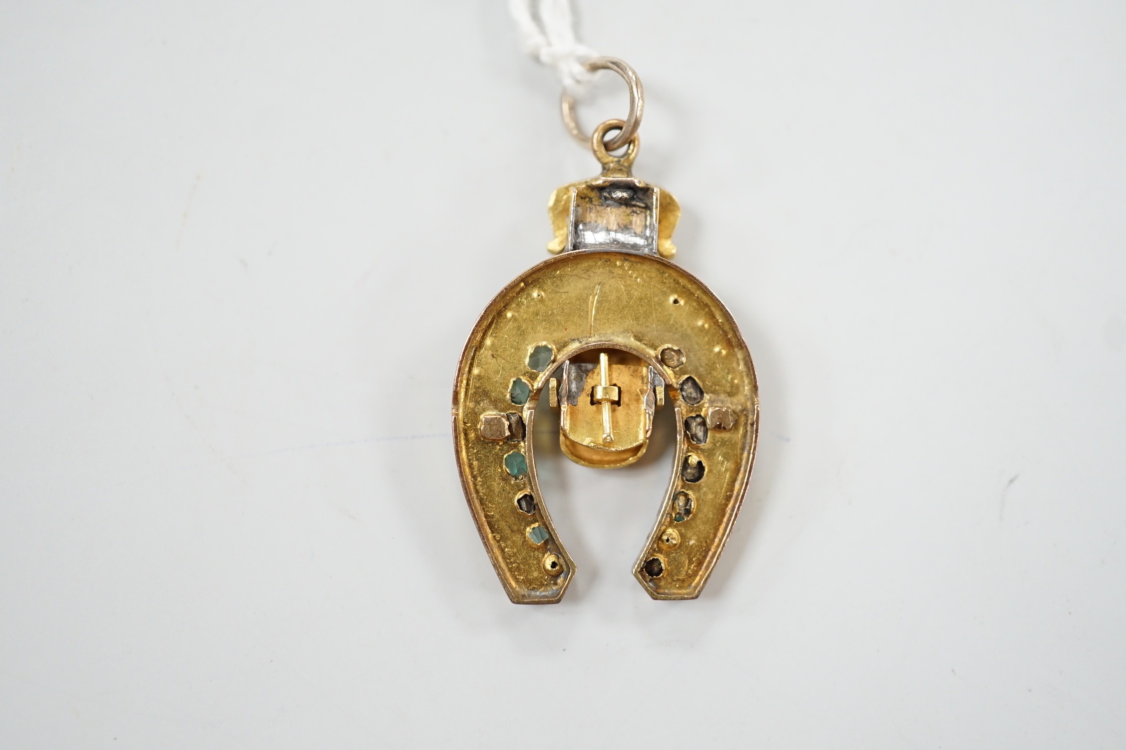 An early 20th century yellow metal, emerald, rose cut diamond and split pearl set horseshoe and buckle pendant, 33mm, gross weight 6 grams.